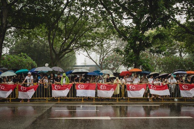 LINING UP. Members of the public wait in the rain for the passing of the funeral procession of late Lee Kuan Yew in Singapore, 29 March 2015. Tom White/EPA 