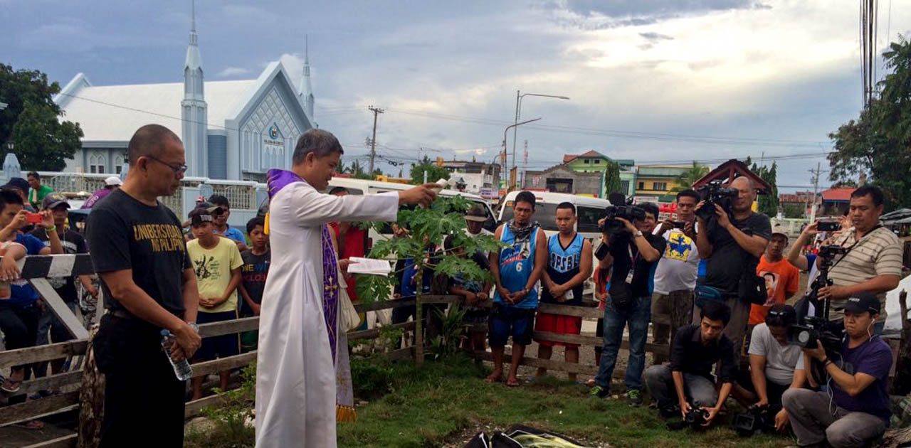 ETERNAL REST. A priest blesses the remains of possible Yolanda victims in Barangay 87 in Tacloban City. on November 7, 2015. Photo by Ayee Macaraig/Rappler 