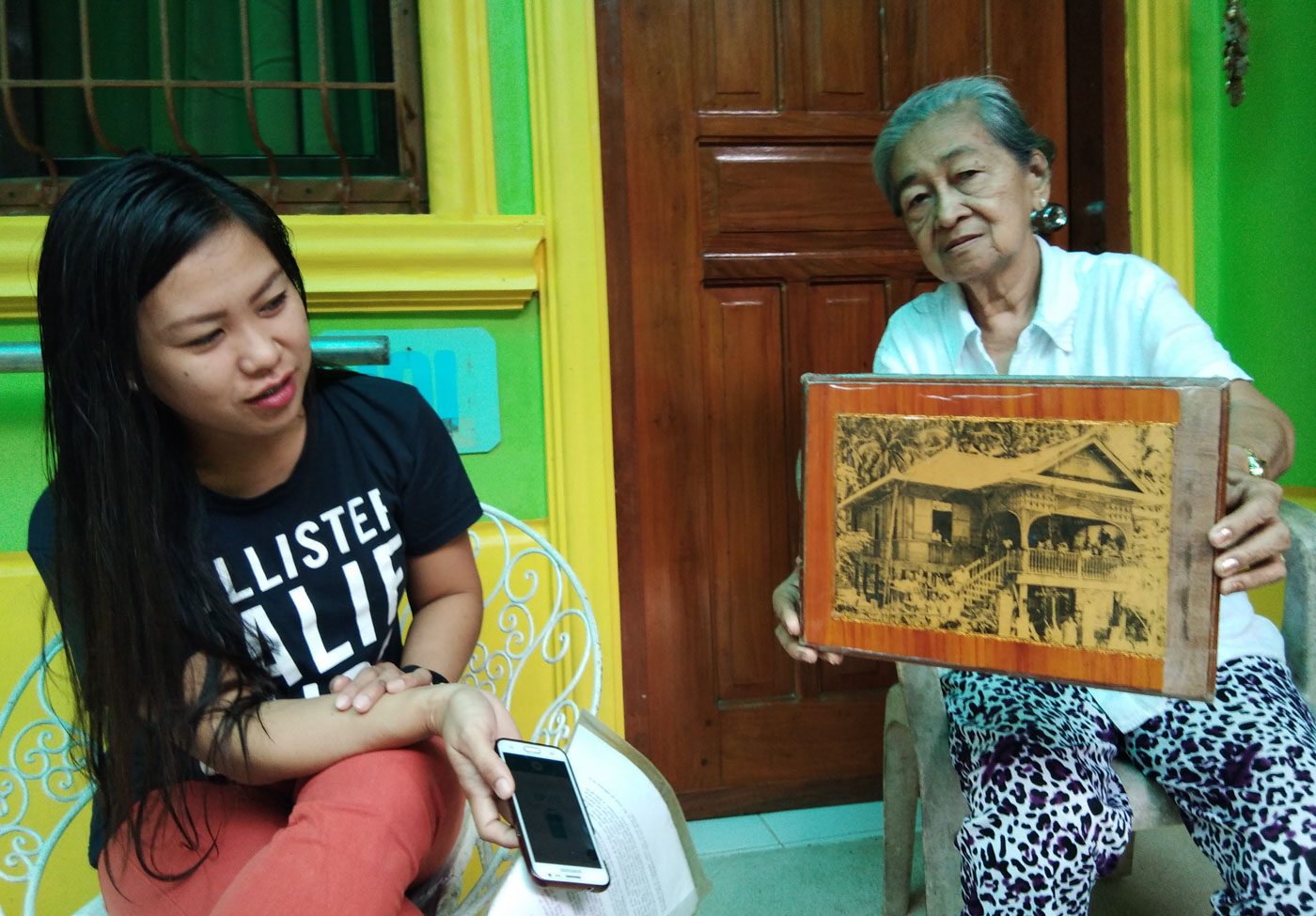 PRESERVATION. Teodora Marcelino Austria holds the photo of their old house.  