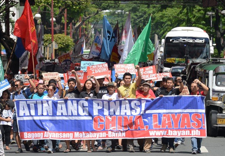 CHINA OUT. Protesters holding placards and streamers shout anti-China slogans as they march in Makati City for a protest against China's presence in disputed waters. Photo by Ted Aljibe/AFP 