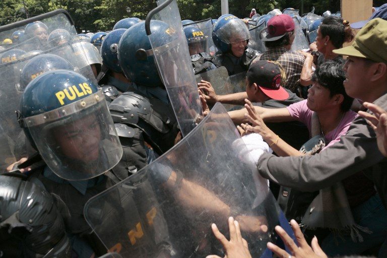 SCUFFLE. Activists clash with police near the United States embassy in Manila. Photo by Joseph Agcaoili/AFP 