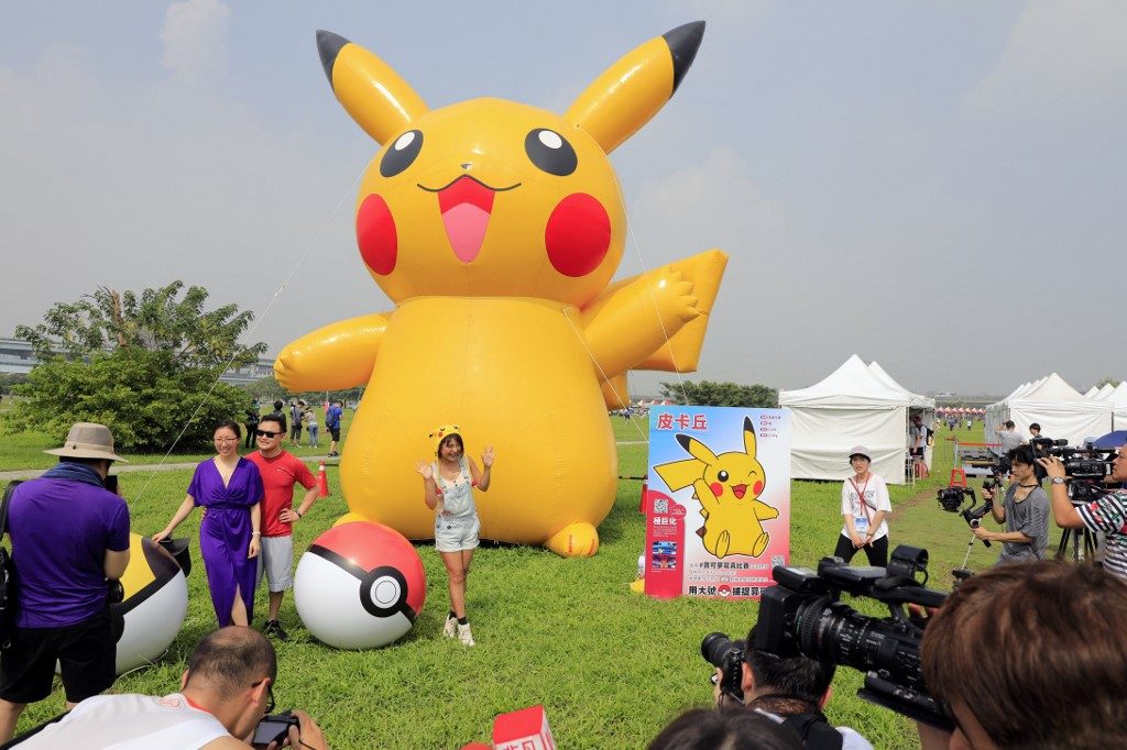 BASE INVASIONS. Visitors pose with Pokemon character Pikachu during the opening day of the Pokemon Go Safari Zone at the New Taipei Metropolitan Park in New Taipei City on October 3, 2019. File photo by Daniel Shih/AFP 