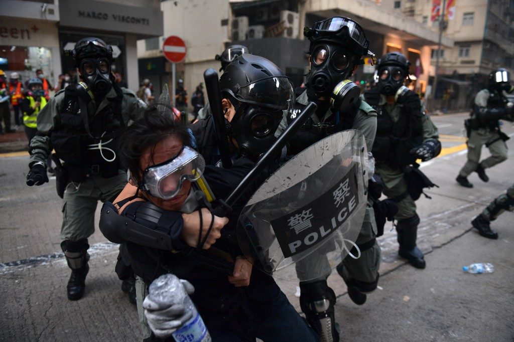 HONG KONG PROTEST. Hong Kong police detain a protester during demonstrations in the Wanchai district in Hong Kong on October 1, 2019, as the city observes the National Day holiday to mark the 70th anniversary of communist China's founding. Photo by Nicolas Asfouri / AFP 