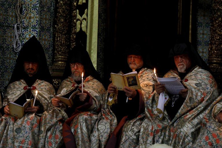 MAUNDAY THURSDAY. Armenian priests hold candles as they pray at the Armenian Saint James Cathedral in Jerusalem's Old City on April 5, 2018, ahead of the traditional Washing of the Feet ceremony during the Armenian Orthodox Holy Week. Photo by Gali Tibbon/AFP  