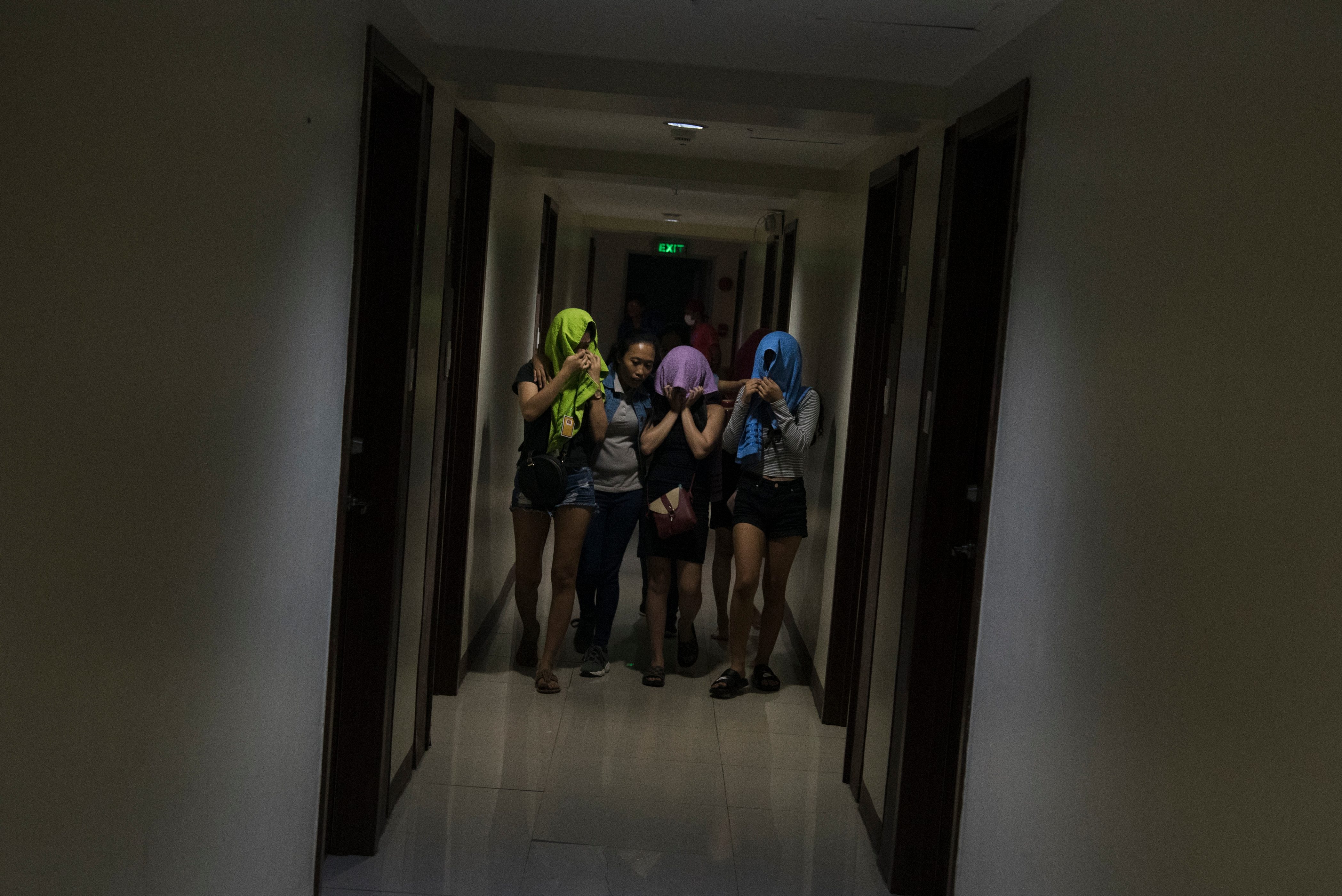 EXIT. A social worker leads rescued victims to the exit of a condominium building following a rescue operation in Marikina City on December 5, 2019.     