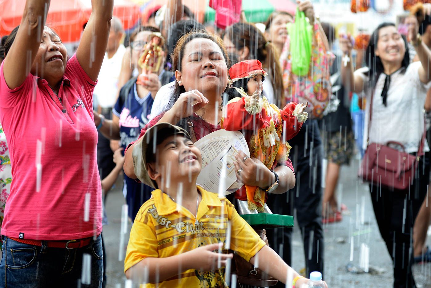 OUTPOURING OF BLESSINGS. Devotees get drenched in holy water as they have their Santo Niño images blessed outside the Santo Niño de Tondo Church in Manila on January 21, 2018. Photo by Maria Tan/Rappler  