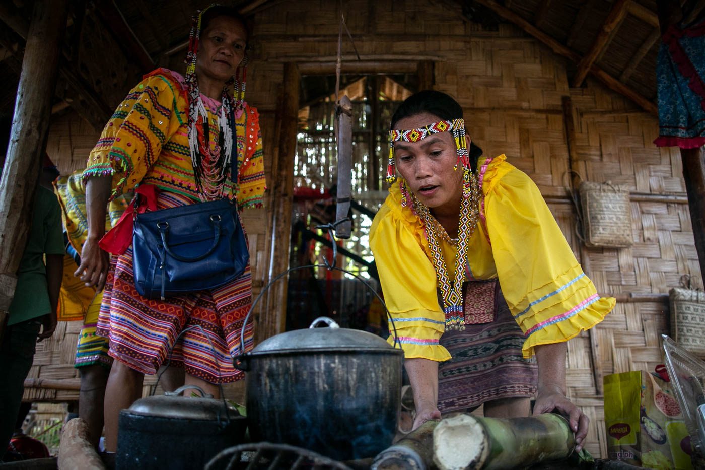 Obu-Manuvu women, shown here using also bamboo, prepare a meal outside their tribal house.
 