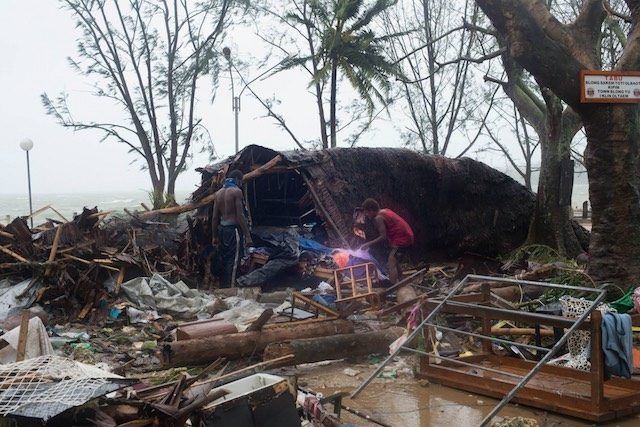 This handout photo taken and received on March 14, 2015 by UNICEF Pacific shows residents looking through storm damage caused by Cyclone Pam, in the Vanuatu capital of Port Vila. Image courtesy UNICEF Pacific 