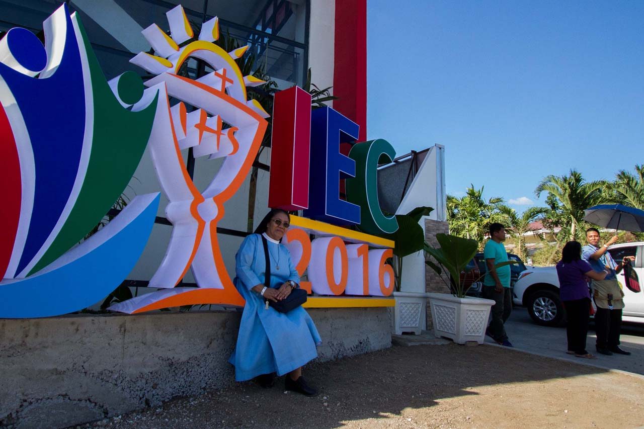 A nun pose for the camera in front of a huge logo of the IEC at the pavilion in Cebu City. Mark Z. Saludes/Rappler 