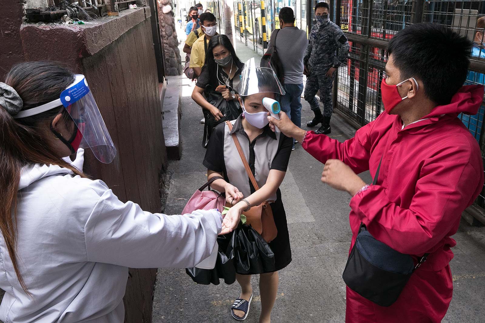 COMMUTING IN COVID-19 TIME. Bus passengers get their temperature checked before boarding. Photo by Darren Langit/Rappler 