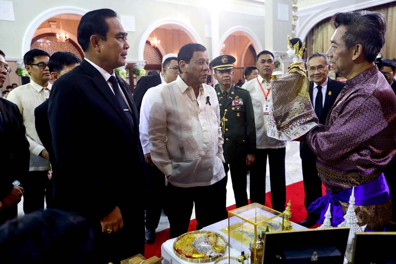 THAI ARTISTRY. The two leaders are shown a figurine made by a Thai craftsman prior to the state dinner 