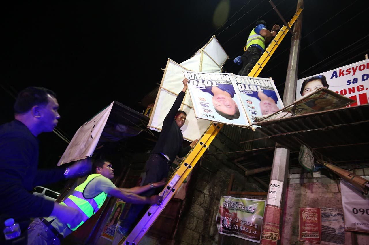 HAZARD. Campaign posters placed in illegal areas are taken down to prevent danger to lives and properties. Photo by Ben Nabong/Rappler 