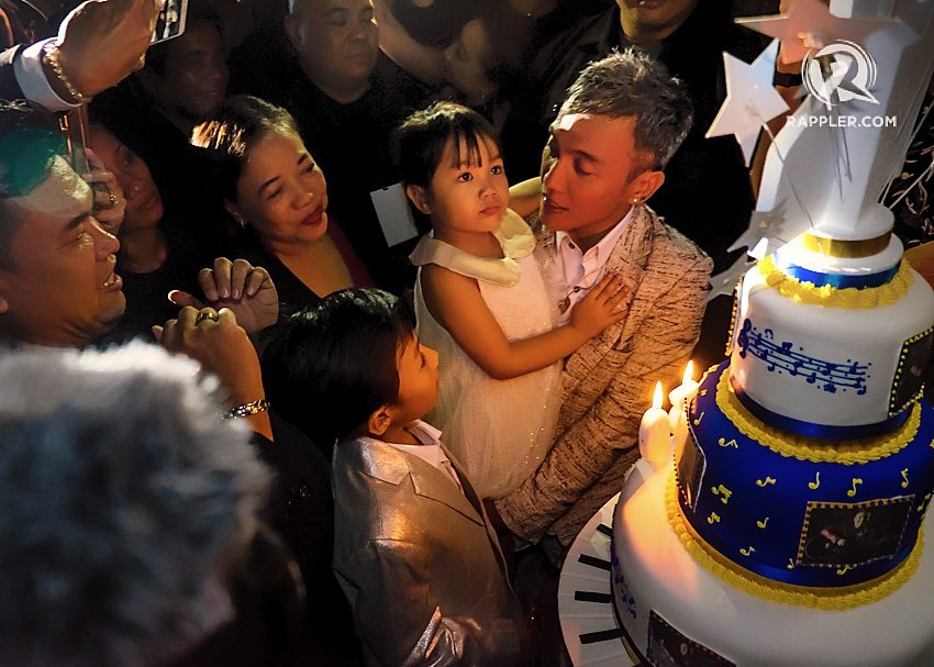 MAKE A WISH.  Arnel carries his daughter Thea as he prepares to blow out the candles. Photo by Stephen Lavoie/ Rappler 