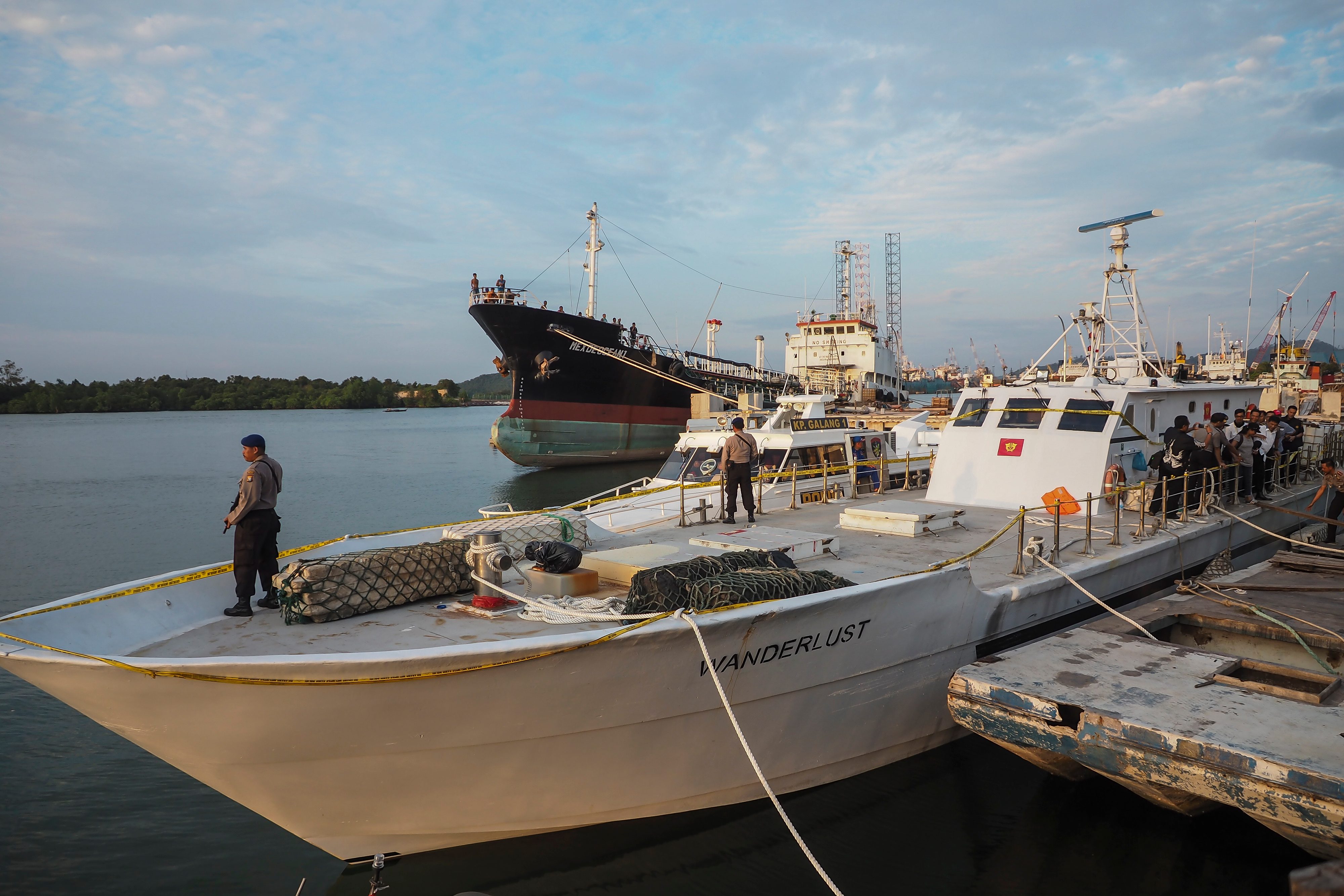 JAGA KAPAL. Polisi menjaga kapal Wanderlust berbendera Sierra Leone di Pelabuhan Bea dan Cukai Tanjung Uncang, Batam, Kepulauan Riau, Senin, 17 Juli. Foto oleh M N Kanwa/ANTARA 