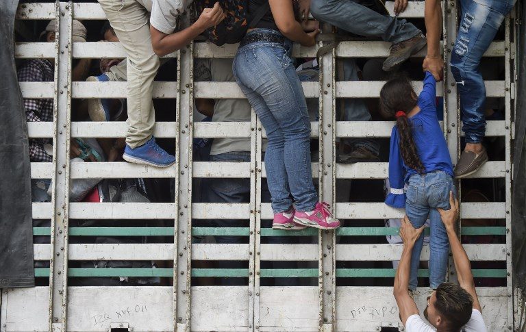EXODUS. Venezuelan migrants climb on a truck on the road from Cucuta to Pamplona, in Norte de Santander Department, Colombia on February 10, 2019. Photo by Raul Arboleda/AFP   