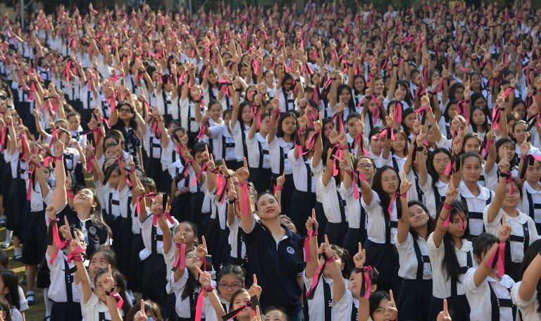 ONE BILLION RISING. Students from St. Scholastica's College gesture a "number one" sign as they take part in the One Billion Rising global movement in Manila on February 14, 2019, as part of the school's Valentine's Day celebrations. Photo by Ted Aljibe/AFP  