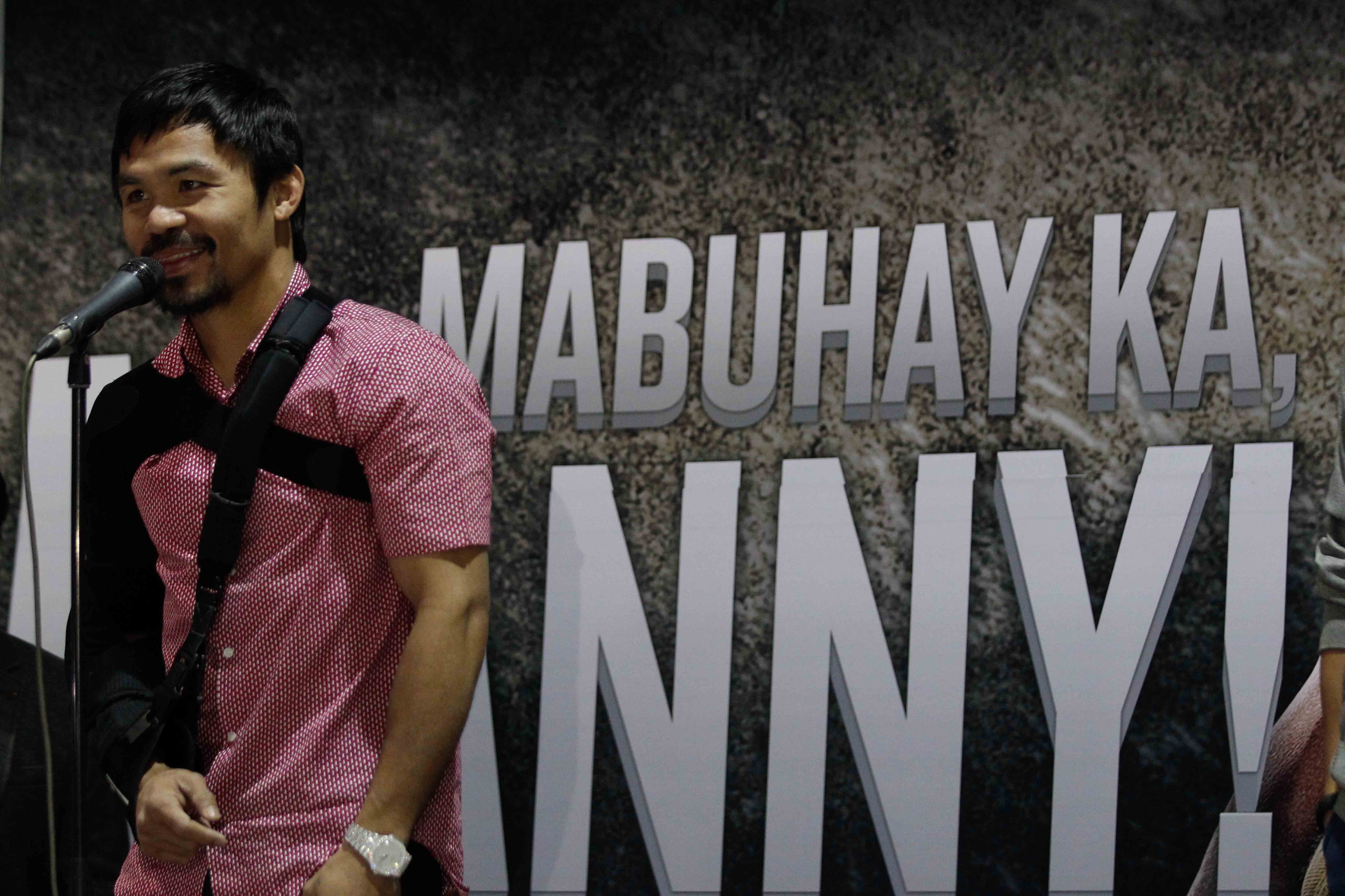 Filipino boxer Manny Pacquiao gestures as he arrives in Manila, Philippines on May 13 ,2015. Photo by Czeasar Dancel 