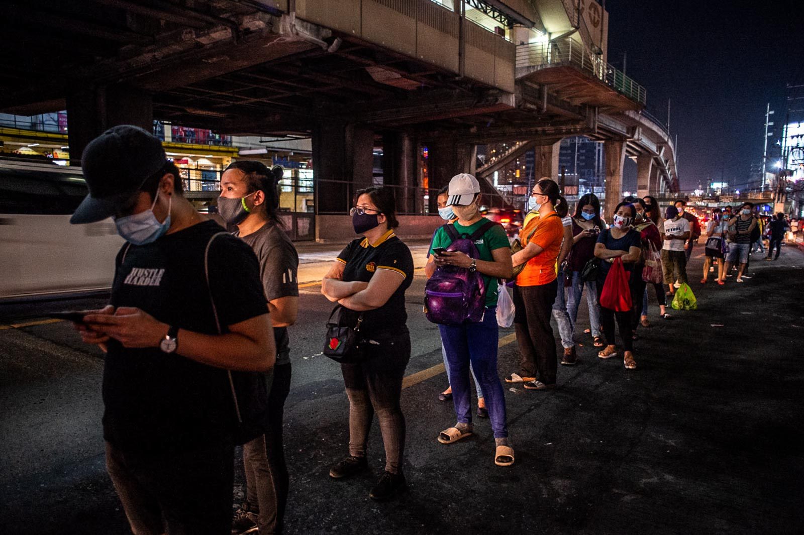 VIRUS THREAT. Commuters waiting for buses observe physical distancing as they queue along EDSA in Quezon City on July 3, 2020. Photo by Lisa Marie David/Rappler 