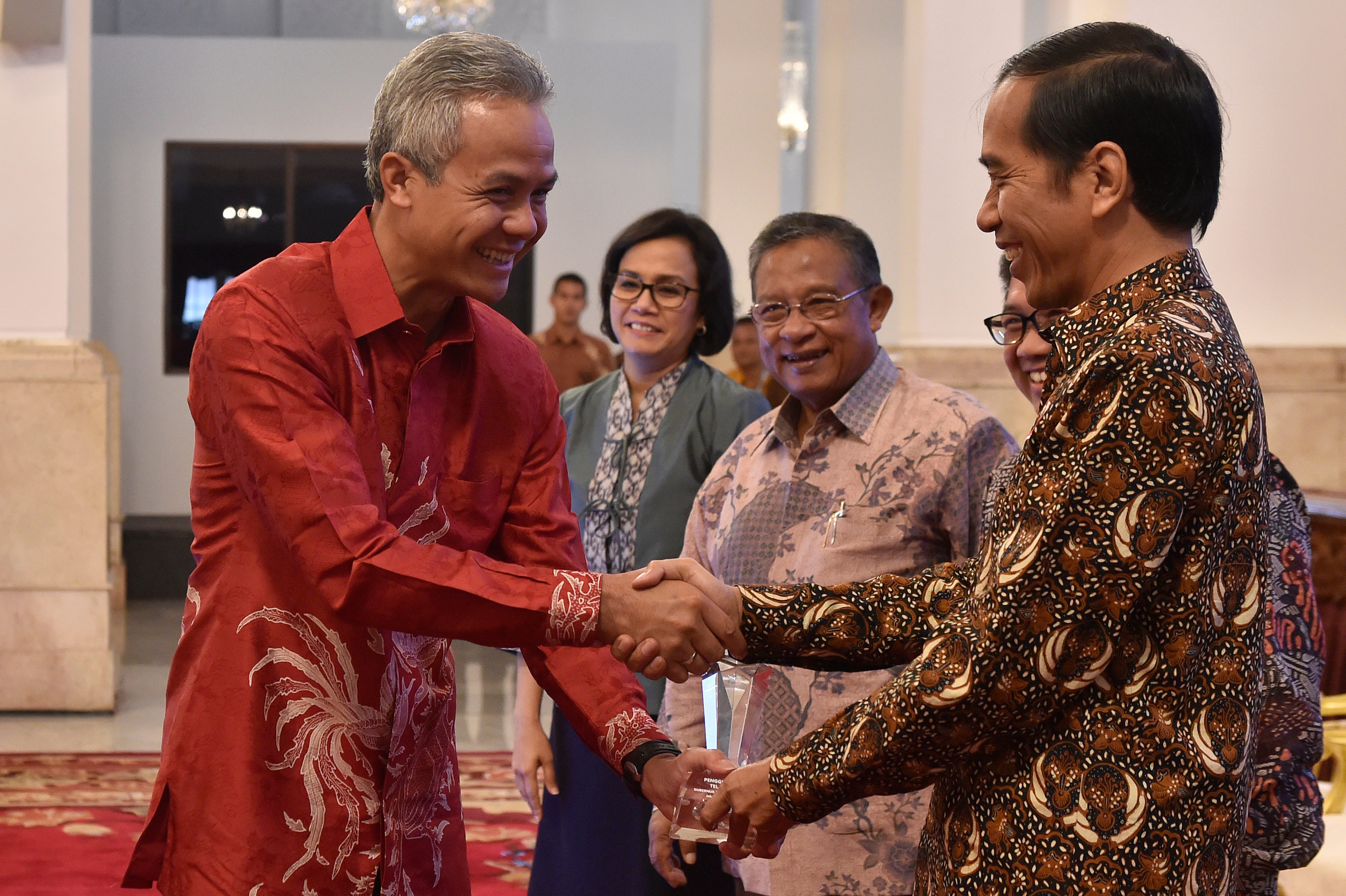 Gubernur Jawa Tengah Ganjar Pranowo (kiri) saat menerima penghargaan dari Presiden Jokowi (kanan) di Istana Negara pada 13 Januari 2017. Foto oleh Puspa Perwitasari/Antara 