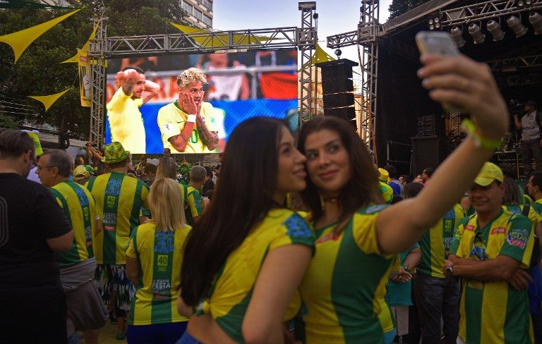 VIEWING PARTY. Fans of Brazil pose for a selfie while attending the broadcast of the World Cup 2018 football match against Switzerland on a big outdoor screen in the Alzirao neighborhood in Rio de Janeiro on June 17, 2018. Photo by Carl de Souza/AFP   
