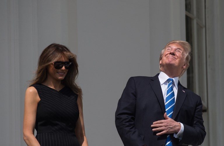 'NOT SO BRIGHT'. US President Donald Trump, with First Lady Melania Trump by his side, checks the partial solar eclipse from the balcony of the White House in Washington, DC, on August 21, 2017. Photo by Nicholas Kamm/AFP   