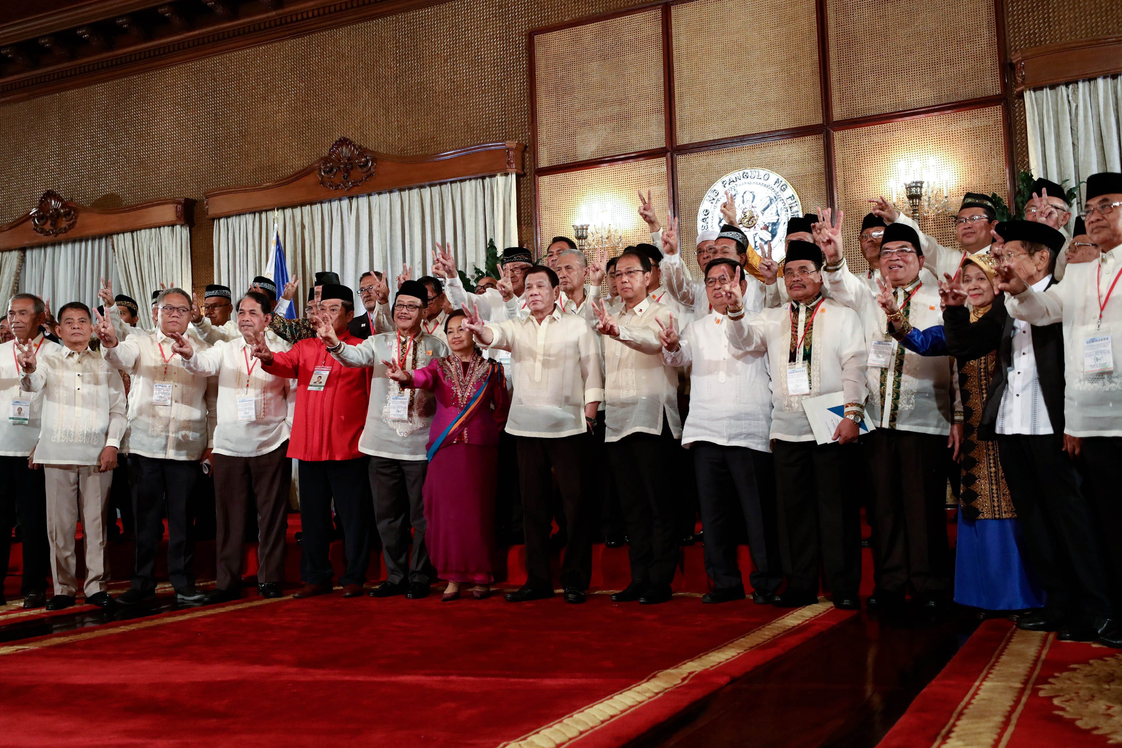 OATH TAKING. President Rodrigo Roa Duterte flashes the peace sign as he poses for a photo with the members of the Bangsamoro Transition Authority following their oath-taking at the Malacañang Palace on February 22, 2019. Photo from Malacañang 