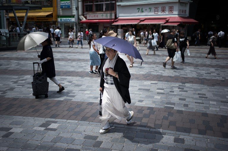 HEATWAVE. A woman holds an umbrella as she walks along a street in Tokyo on July 23, 2018, as Japan suffers from a heatwave. Photo by Martin Bureau  