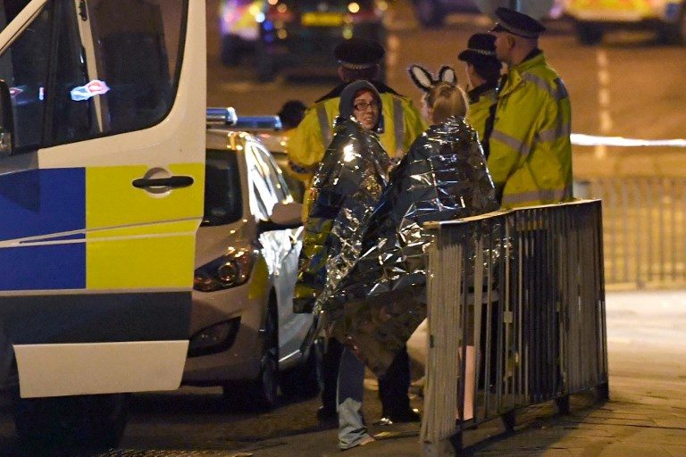 MANCHESTER ATTACK. Concert goers wait to be picked up at the scene of a suspected terrorist attack during a pop concert by US star Ariana Grande in Manchester, England on May 23, 2017. Photo by Paul Ellis/AFP  