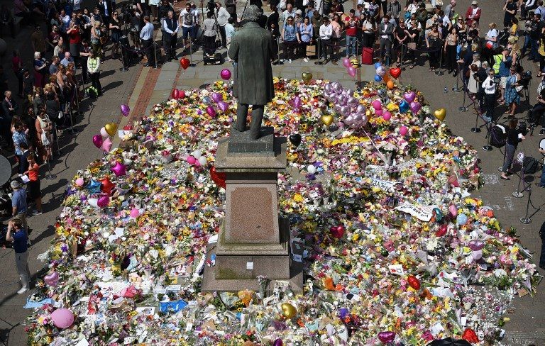 TRIBUTE. People gather to see flowers and messages of support left around a statue of Richard Cobden in St Ann's Square in Manchester, England on May 25, 2017. Photo by Oli Scarff/AFP   