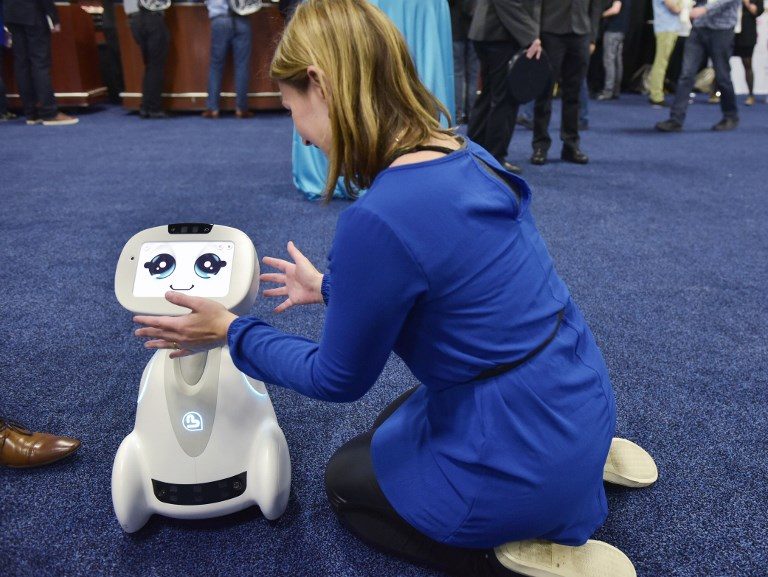 BUDDY. A woman plays with Buddy the companion robot by Blue Frog Robotics is seen on display during the CES Unveiled preview event at the Mandalay Bay Convention Center during CES 2018 in Las Vegas on January 7, 2018. Photo by Mandel Ngan/AFP 