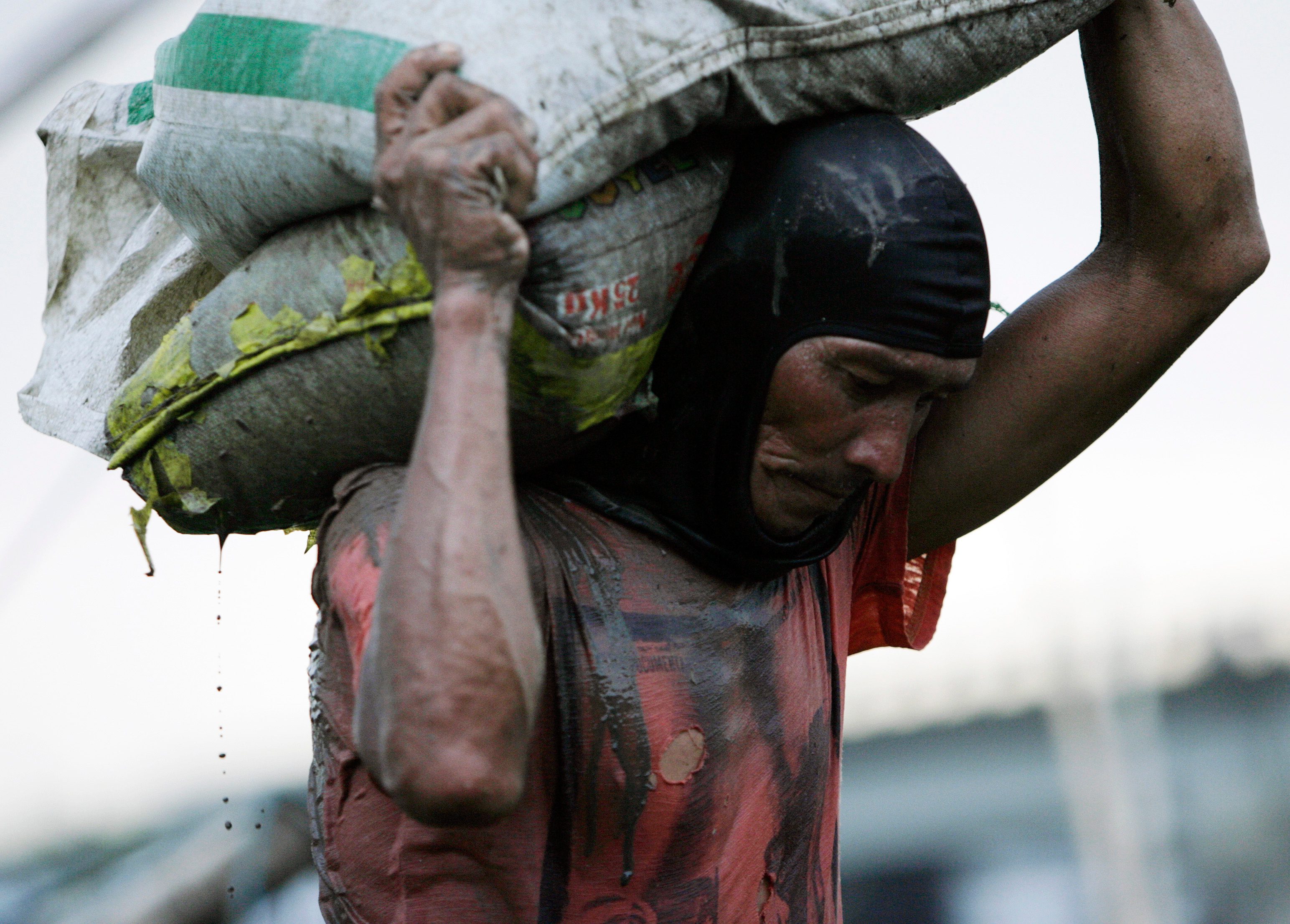 HARD LABOR. A Filipino laborer carries sacks. Photo by Francis Malasig/EPA  