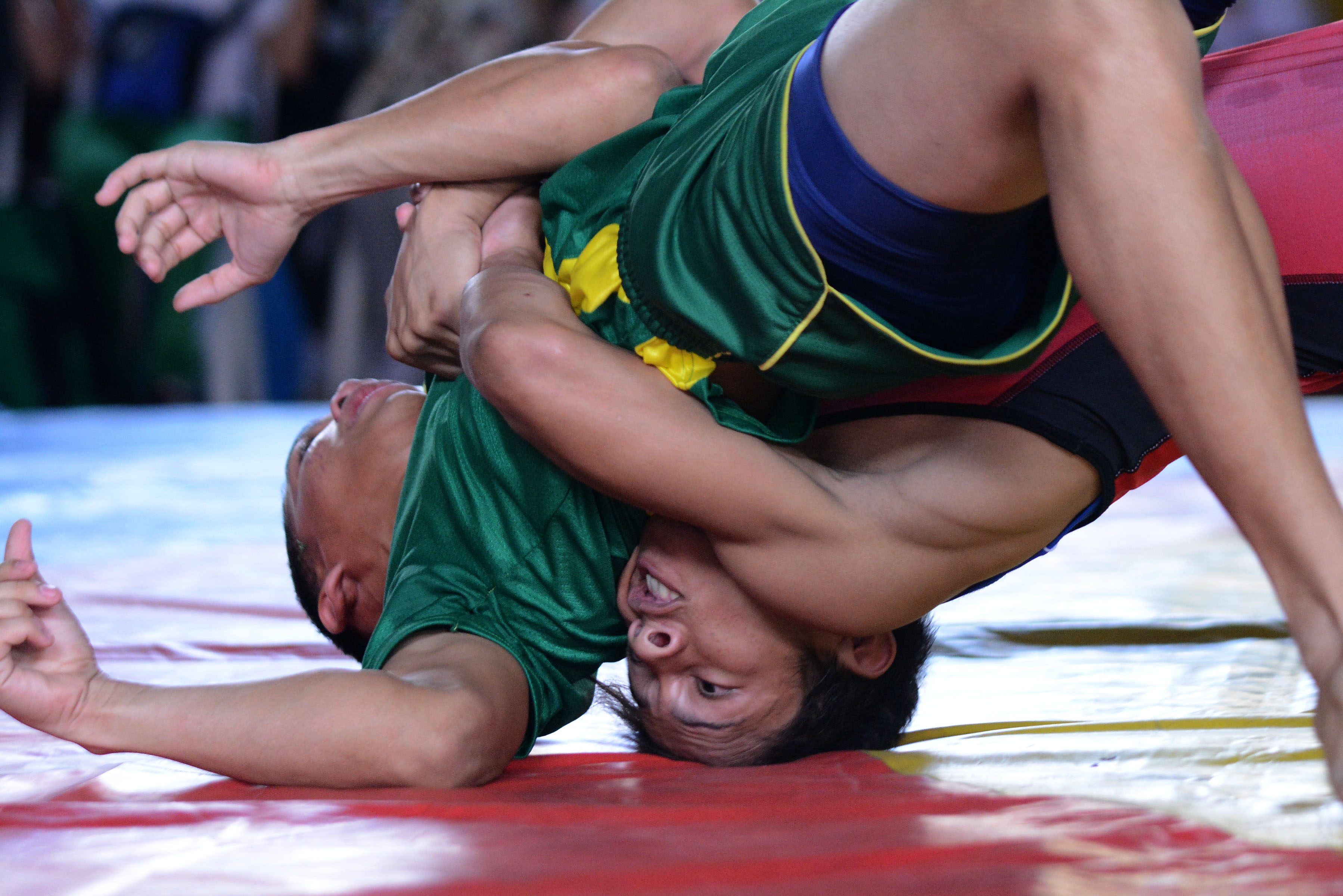 ON THE MAT. Wrestlers grapple on the mat during a match. Photo by Roy Secretario/ Rappler 