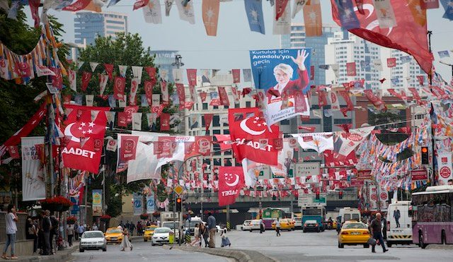 CAMPAIGN FIESTA. People walk under campaign flags and posters in Istanbul, Turkey, June 5, 2015. Tolga Bozoglu/EPA 