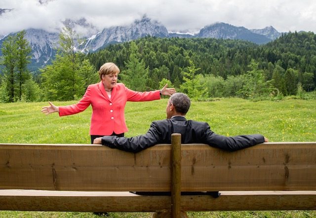 MEME-WORTHY. German Chancellor Angela Merkel talks to US President Barack Obama who sits on a bench facing the Wetterstein mountains at Elmau Castle in Elmau, Germany, June 8, 2015. Michael Kappeler/Pool/EPA 