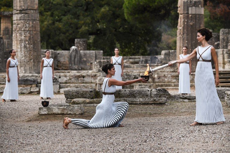 OLYMPIC FLAME. Actress Katerina Lechou (R), acting the high priestess, lights the Olympic flame at the Temple of Hera in Olympia, the sanctuary where the Olympic Games were born in 776 BC, during the lighting ceremony of the Olympic flame for the 2018 Winter Olympics in Pyeongchang, South Korea, on October 24, 2017. Photo by Aris Messinis/AFP   