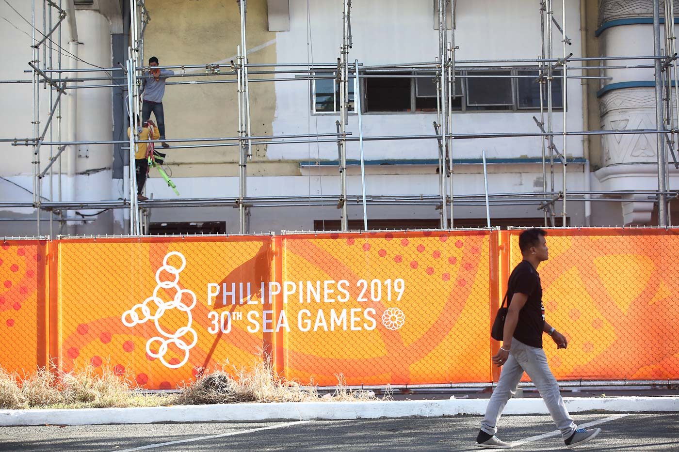LAST MINUTE. Workers are trying to complete the repainting of the facade of the Rizal Memorial Stadium on the same day it hosts the football competition. Photo by Ben Nabong/Rappler  