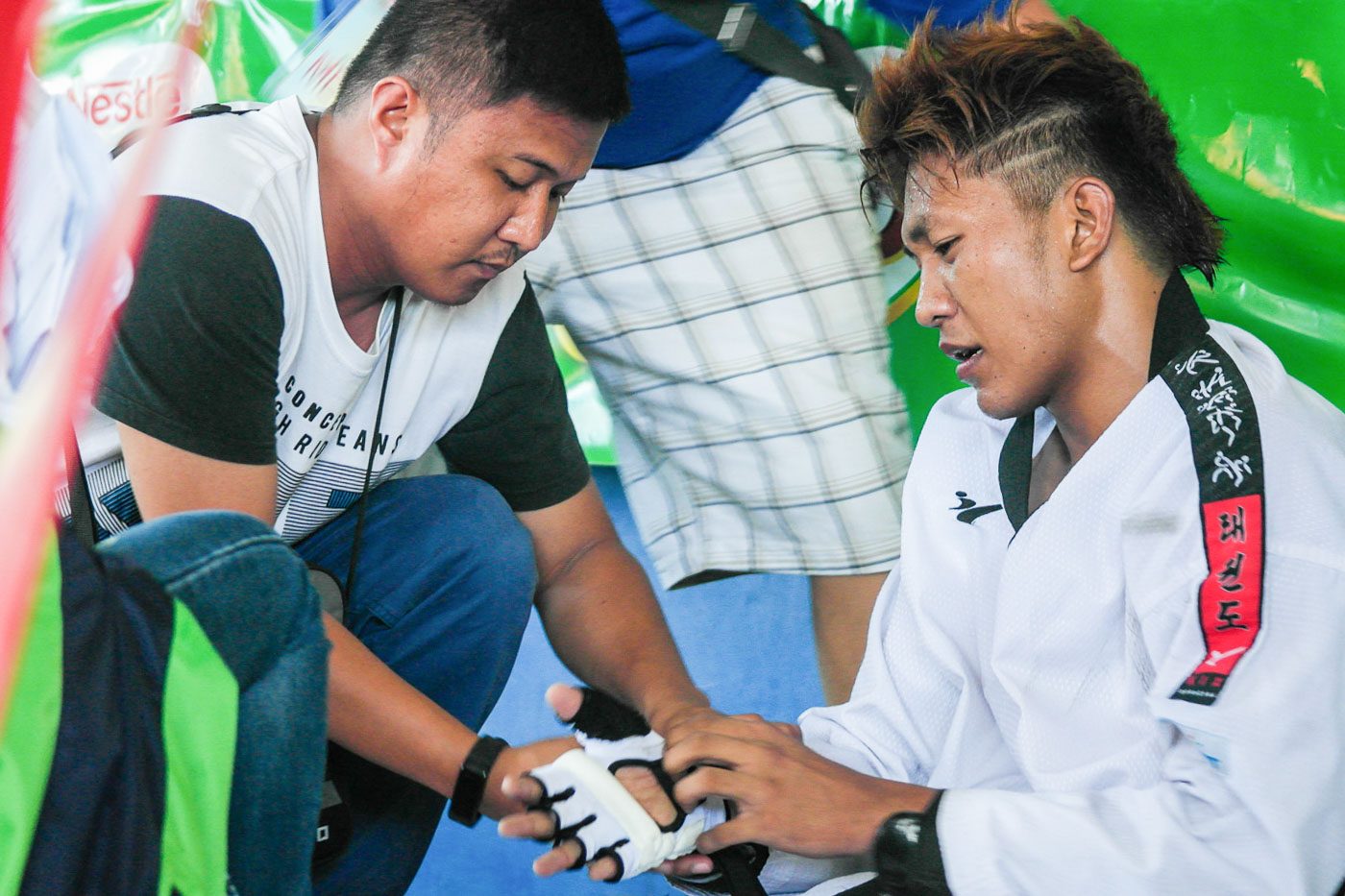 BRUISED BUT UNBROKEN. Taekwondo athlete Angelo Maggay falters during the qualifying rounds of Secondary Boys Taekwondo after experiencing muscle cramps in the middle of the match.  