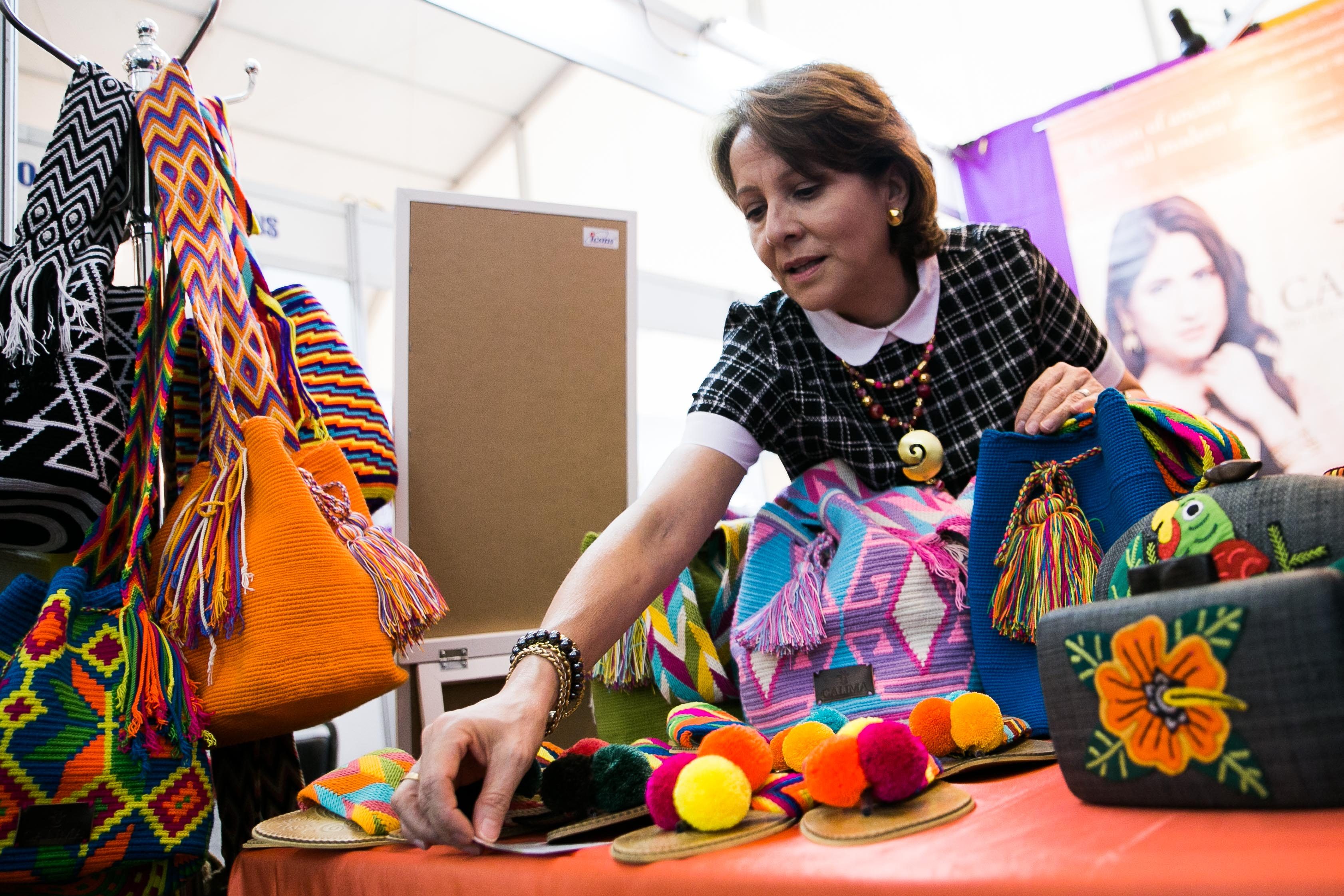 FROM CALIMA. Colombian Claudia Hernandez fixes her products at the APEC International Media Center. She sells sandals, bags, and purses made by the Wayuu tribe in Colombia, and jewelry inspired by Colombian designs. Photo by Pat Nabong/Rappler