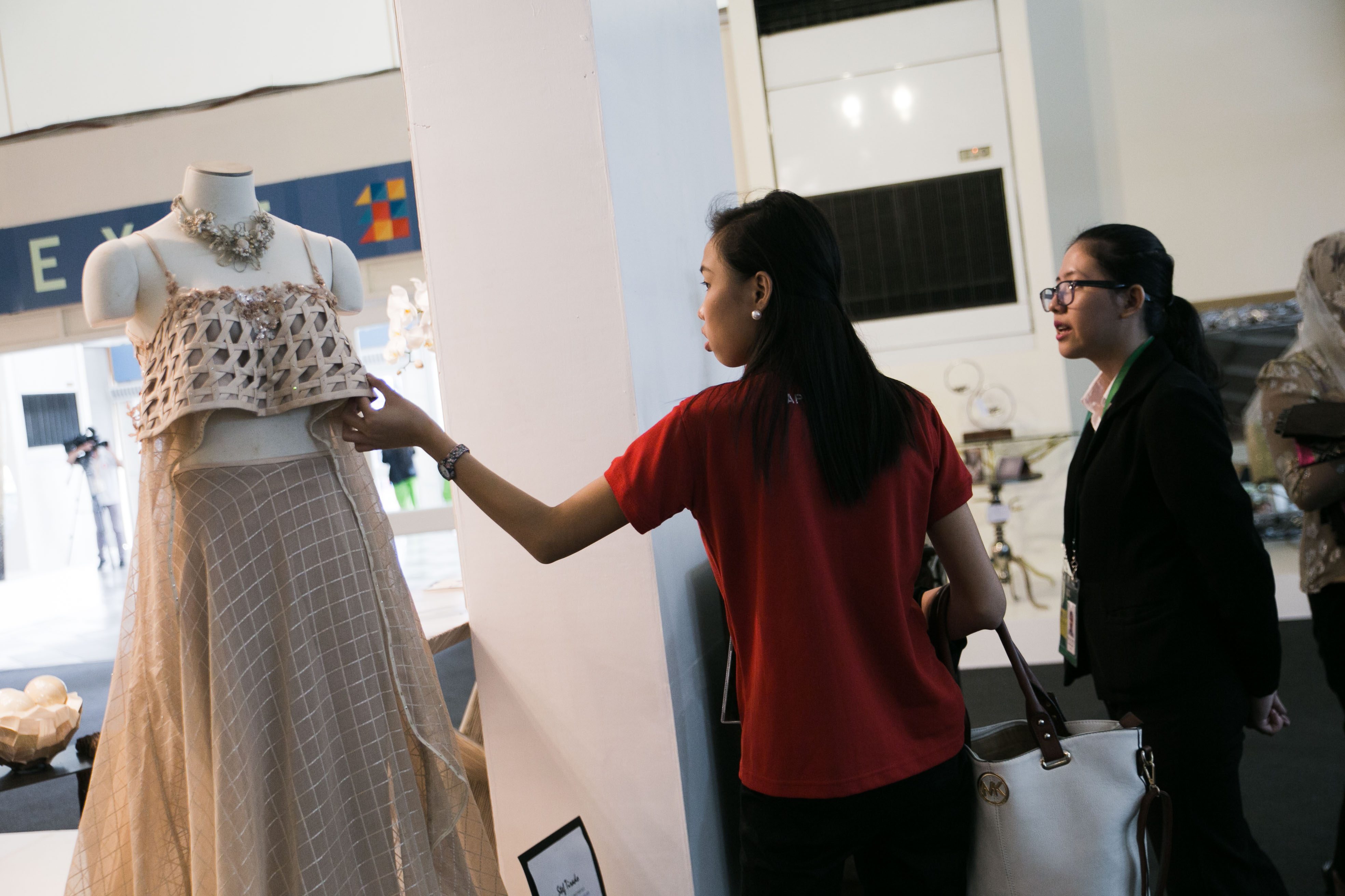 POTENTIAL BUYERS. Two women examine a gown that was exhibited by Expo Mandaue at the APEC International Media Center. Mandaue is a springboard of many businesses that hope to be and already are part of the export economy. Photo by Pat Nabong/Rappler