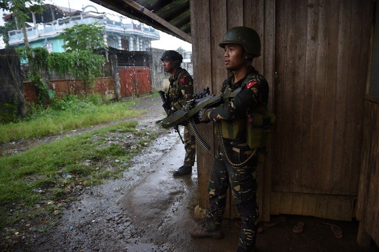MARAWI CLASHES. Government troops take position against enemy snipers as they escort rescued workers and trapped residents near the town center of Marawi on June 1, 2017 where heavy fighting between soldiers and the Maute Group have been raging. Photo by Ted Aljibe/AFP 