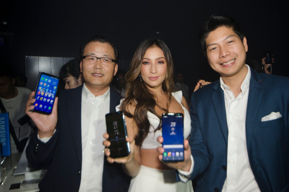 Solenn Huessaff with Samsung executives holding the new Samsung Galaxy 8.  