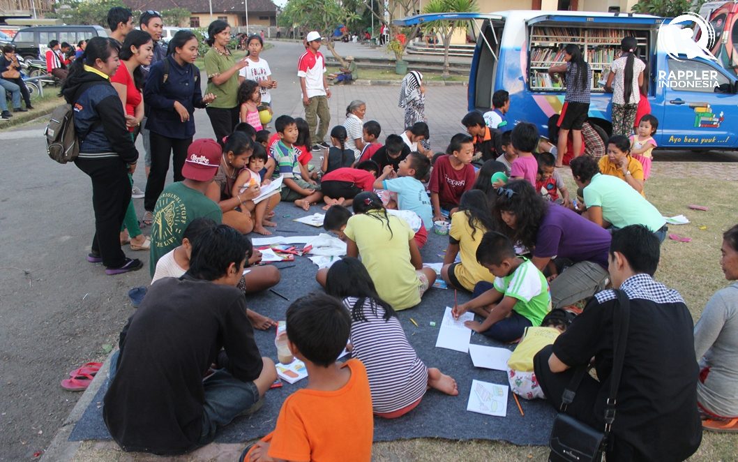 AKTIVITAS SORE. Anak-anak di pos pengungsian GOR Swecapura mengisi aktivitas sore hari, membaca, menggambar, dan mewarnai. Foto oleh Bram Setiawan/Rappler 