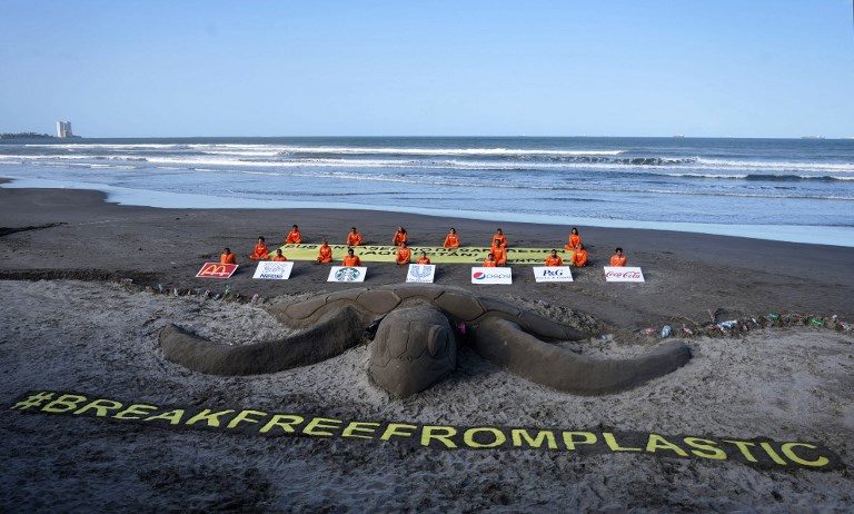PLASTIC USE PROTEST. Greenpeace activists pose next to a 12-meter-long sand turtle demanding that big companies worldwide commit to stop using plastic containers and opt for less aggressive alternatives for the environment, in Boca del Rio, Veracruz State, Mexico, on April 15, 2018. Photo by Victoria Razo/AFP  