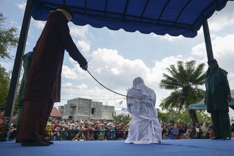 MAKING IT PUBLIC. A woman is publicly flogged in front of a mosque in the provincial capital Banda Aceh on April 20, 2018.  Photo by Chaideer Mahyuddin/AFP  