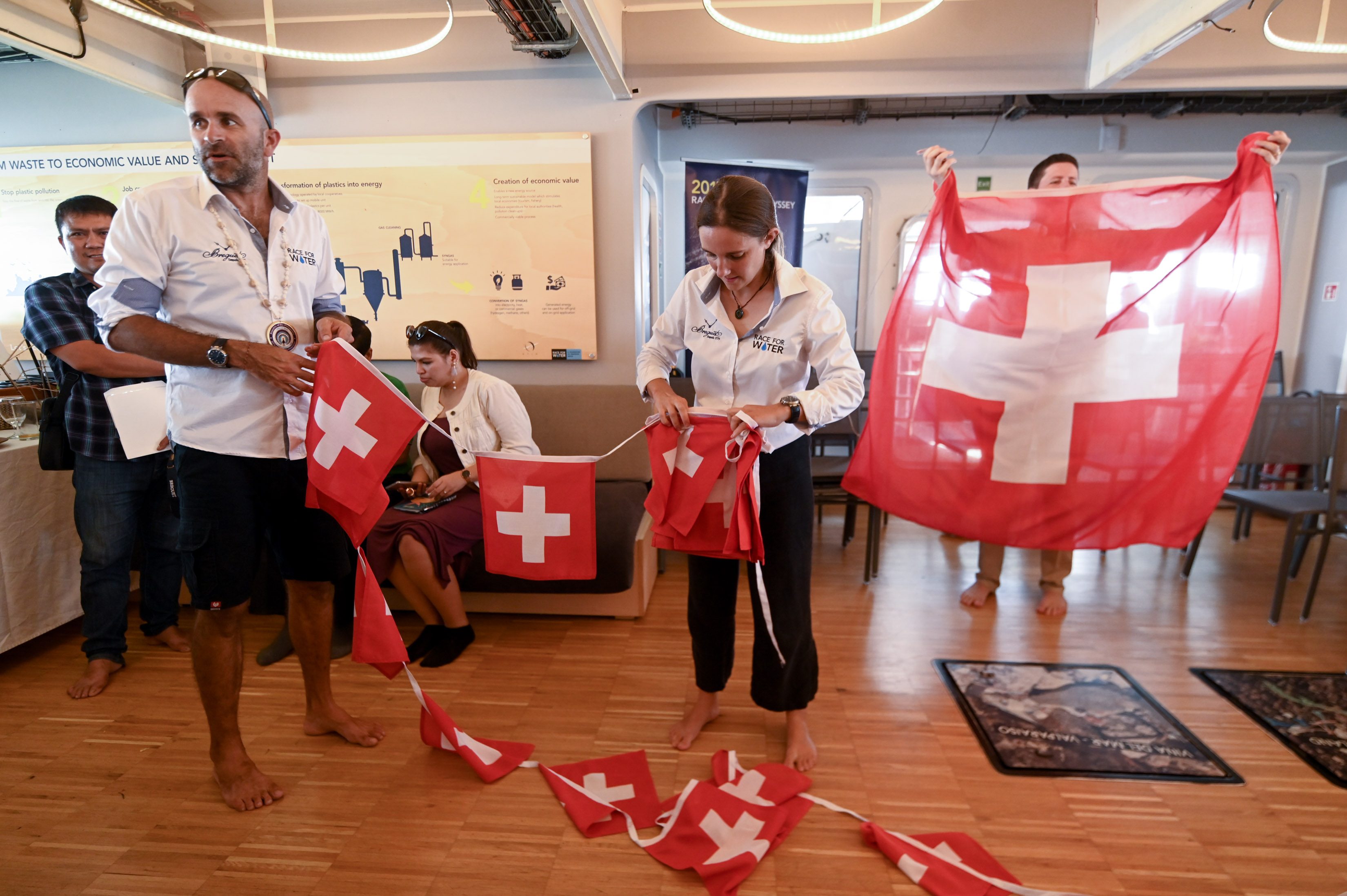 CLEANUP. Crew members tidy the lobby and folds the Swiss flag neatly until the next event. Photo by Alecs Ongcal/Rappler   