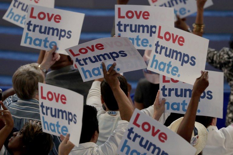 Delegates hold up signs that read 'Love trumps hate' during the opening of the first day of the Democratic National Convention at the Wells Fargo Center, July 25, 2016 in Philadelphia, Pennsylvania. Alex Wong/Getty Images/AFP 