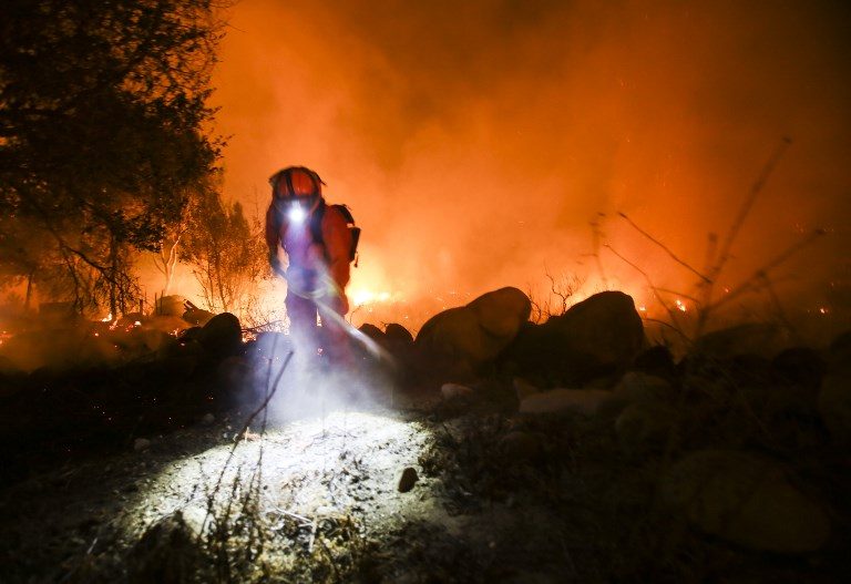 VENTURA COUNTY. Firefighters battle a wildfire as it burns along a hillside near homes in Santa Paula, California, on December 5, 2017. Photo by Ringo Chiu/AFP  