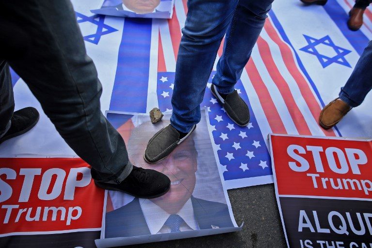NO TO JERUSALEM. Palestinian protesters step on US and Israeli flags and on a portrait of US President Donald Trump following his decision to recognize Jerusalem as the capital of Israel on December 7, 2017. Photo by Mohammed Abed/AFP  