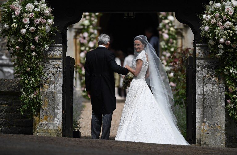 Pippa Middleton, (R) is escorted by her father Michael Middleton, as she arrives for her wedding to James Matthews at St Mark's Church in Englefield, west of London, on May 20, 2017. Photo by Justin Tallis/AFP Photo 