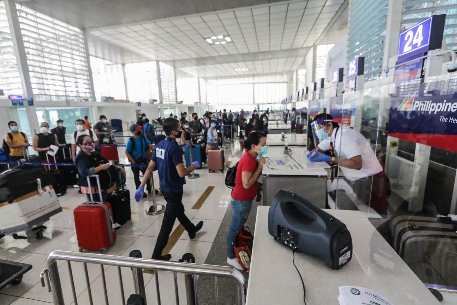 ALMOST HOME. Returning OFWs queue at terminal counters at the NAIA Terminal 2 in Pasay City on May 27, 2020. Photo by Ben Nabong/Rappler    
